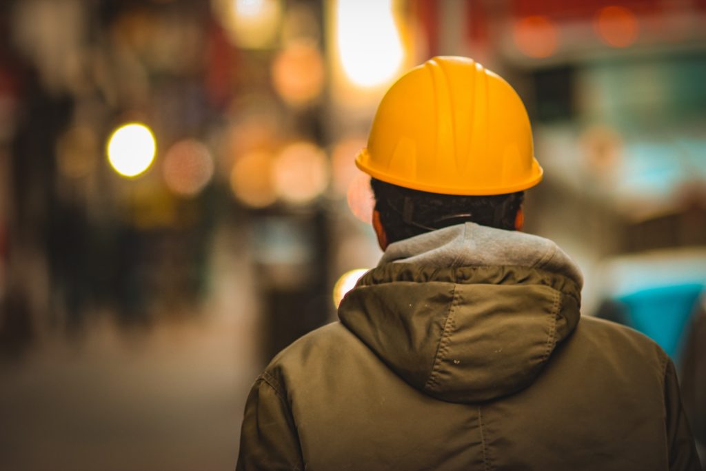 person in yellow hard hat and brown jacket